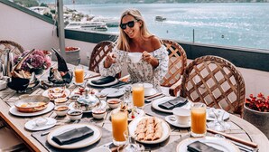 A table set for breakfast with a view of the water and a bridge in the background. - Shangri-La Bosphorus, Istanbul (Istanbul)