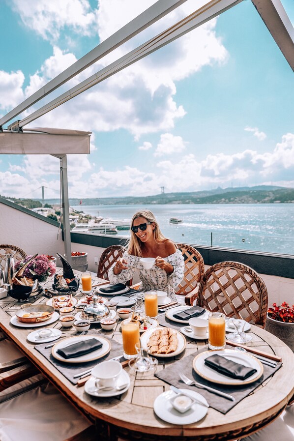 A table set for breakfast with a view of the water and a bridge in the background. - Shangri-La Bosphorus, Istanbul (Istanbul)