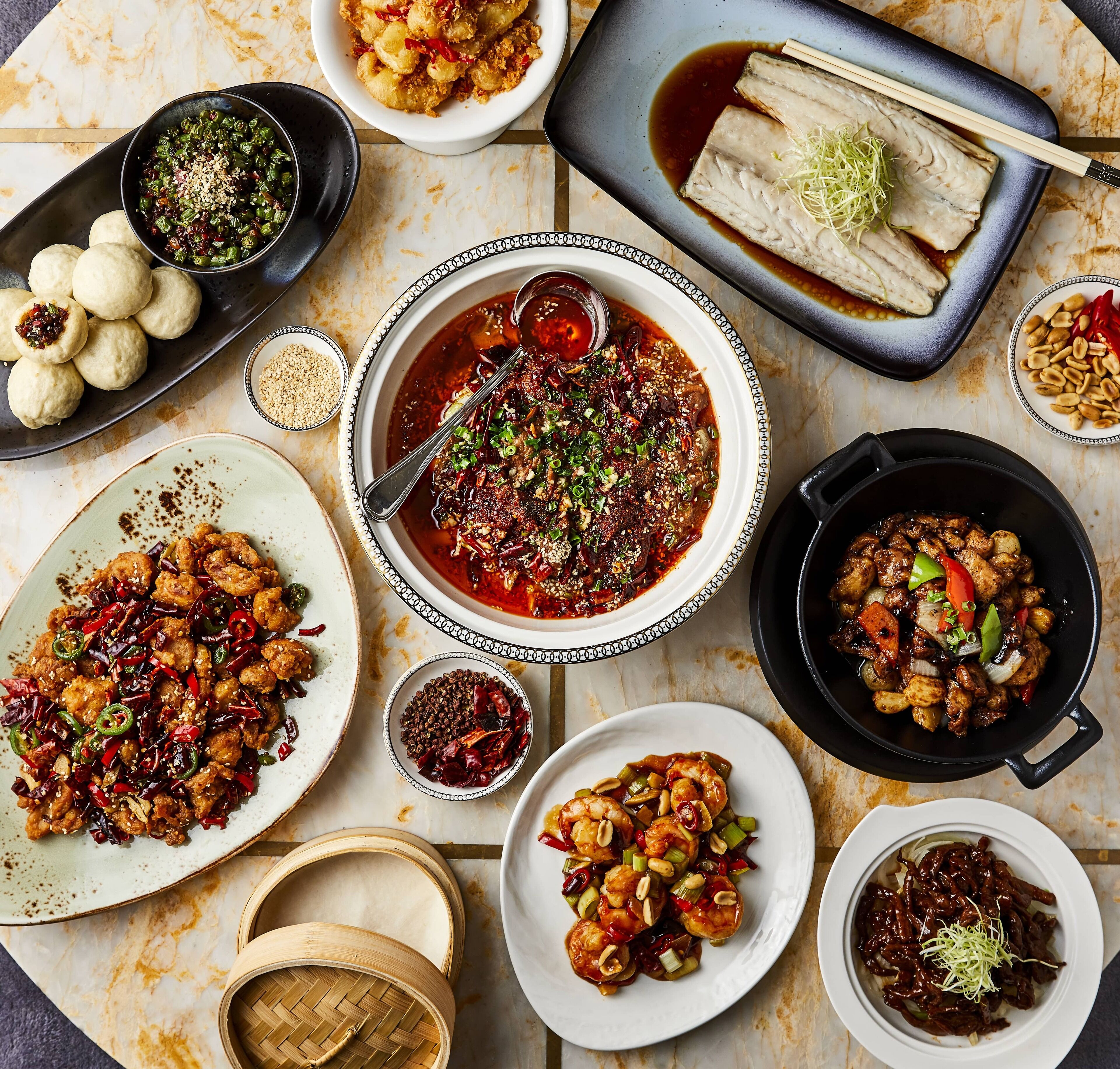A variety of dishes including dumplings, a bowl of soup, and stir-fried meat.