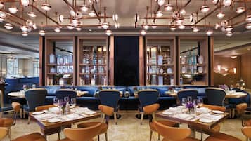 A restaurant with multiple dining areas, including booths and tables, and a variety of lighting fixtures.