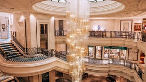 A grand atrium with a central chandelier, multiple levels with balconies, and a staircase leading to the upper floors. - Shangri-La Bosphorus, Istanbul (Istanbul)