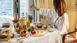 A breakfast table with various dishes, a window with curtains, and a view of the sea. - Shangri-La Bosphorus, Istanbul (Istanbul)