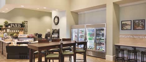 A restaurant with a bar area, a refrigerator stocked with beverages, and a 'PARIS' sign on the wall.