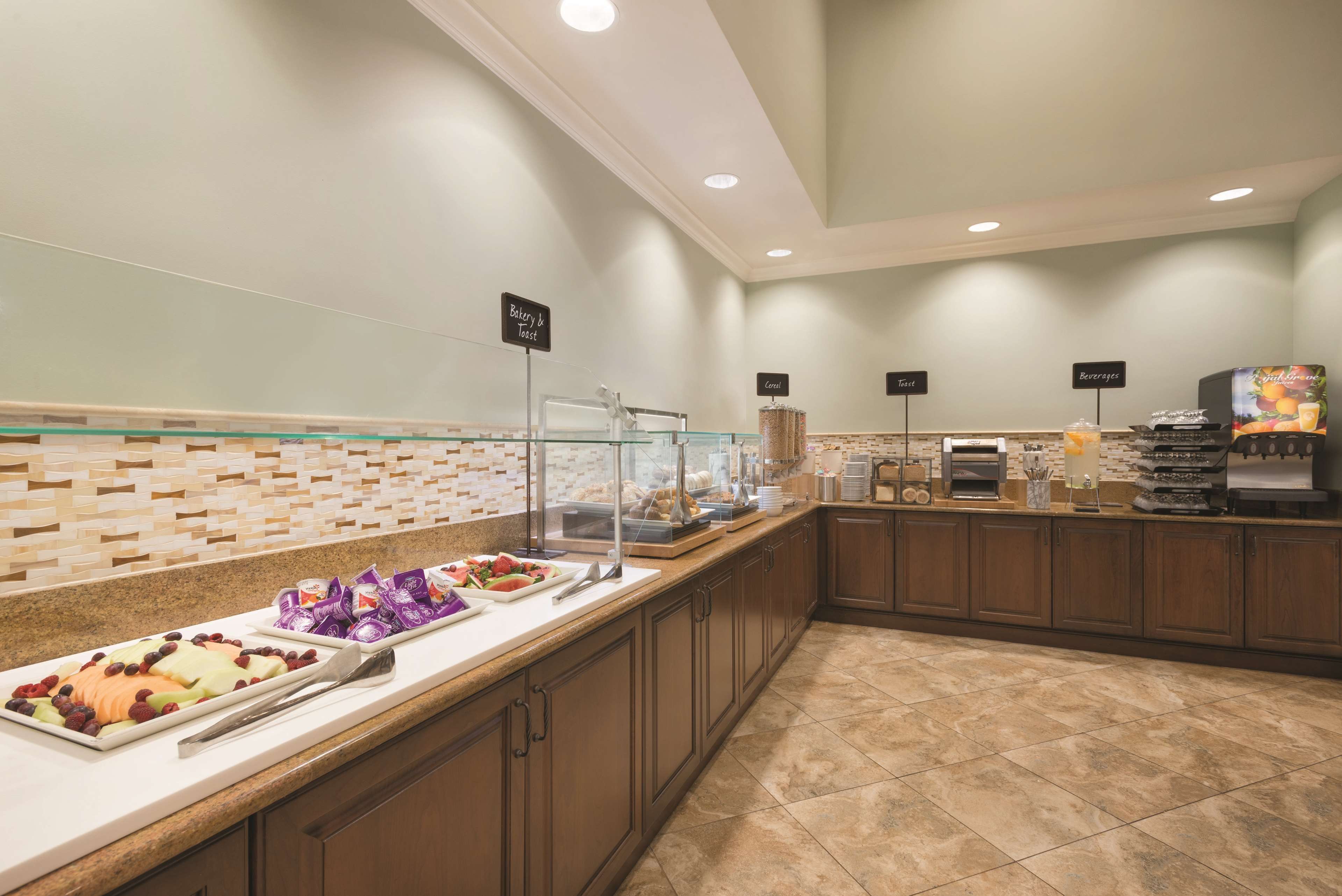 A buffet area with labeled sections for bakery, cereal, and beverages.