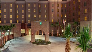 A hotel entrance with a brick facade, multiple windows, and a central archway marked with an 'E' for emergency exit. - Embassy Suites by Hilton Savannah Historic District (Savannah)