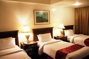 Habitación triple Deluxe | Minibar, caja fuerte, escritorio y cortinas opacas