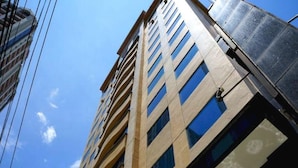 A tall building with multiple floors and large windows. - Tiara Oriental Hotel Makati powered by Cocotel (Makati)