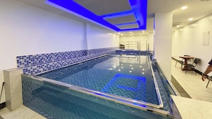 An indoor swimming pool with blue-tiled walls and a glass barrier. - Tiara Oriental Hotel Makati powered by Cocotel (Makati)