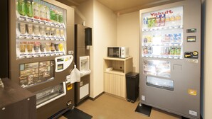 A vending machine area with various drink options and a microwave. - Dormy Inn Express Matsue (Matsue)
