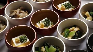 A variety of small bowls containing different dishes, likely part of a meal or tasting menu.