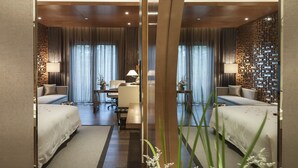 Una habitación de hotel moderna con una cama grande, un escritorio y un área de descanso.
