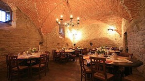 Un comedor rústico con paredes de ladrillo y mesas y sillas de madera.