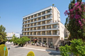 A multi-story hotel with a central courtyard, balconies, and outdoor seating areas. - Semeli Hotel (Nicosia)