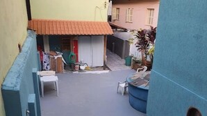 Ein Innenhof mit einem kleinen Gebäude, Gartenmöbeln und einer blauen Wand.