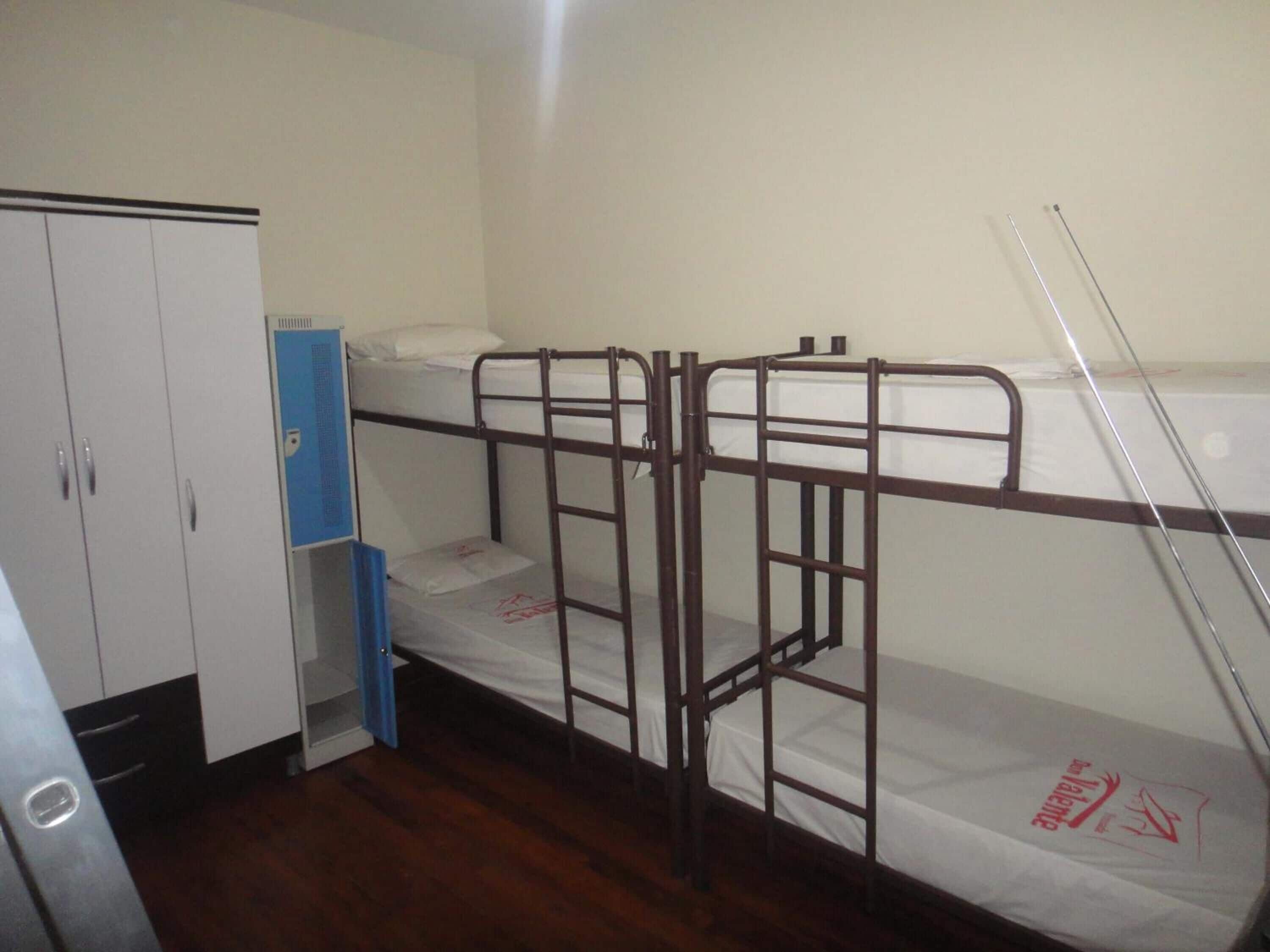 A bunk bed room with a wardrobe and a desk.