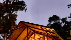 A two-story wooden house with a balcony, surrounded by tropical vegetation. - Casa Divina Eco Lodge (Mindo)