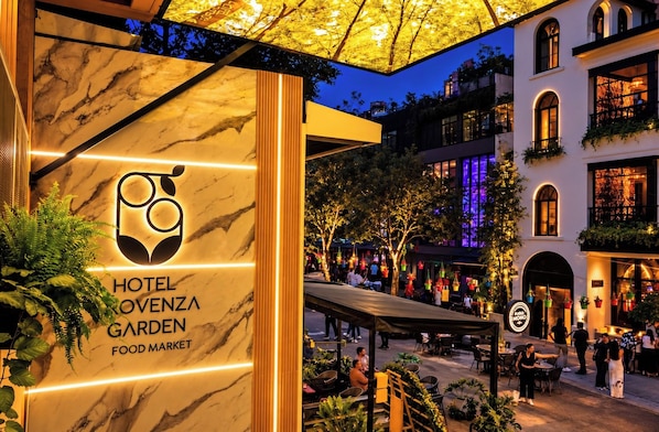 Un hotel con fachada de mármol y un mercado de alimentos.