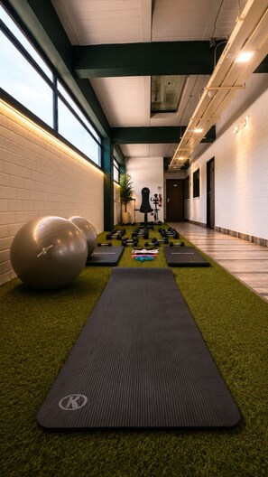 A gym with exercise equipment, a yoga mat, and a wall-mounted exercise bike.