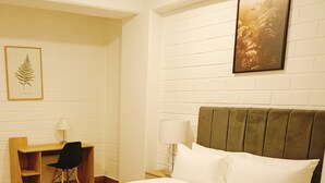 Una habitación de hotel con una cama, un escritorio y una silla.
