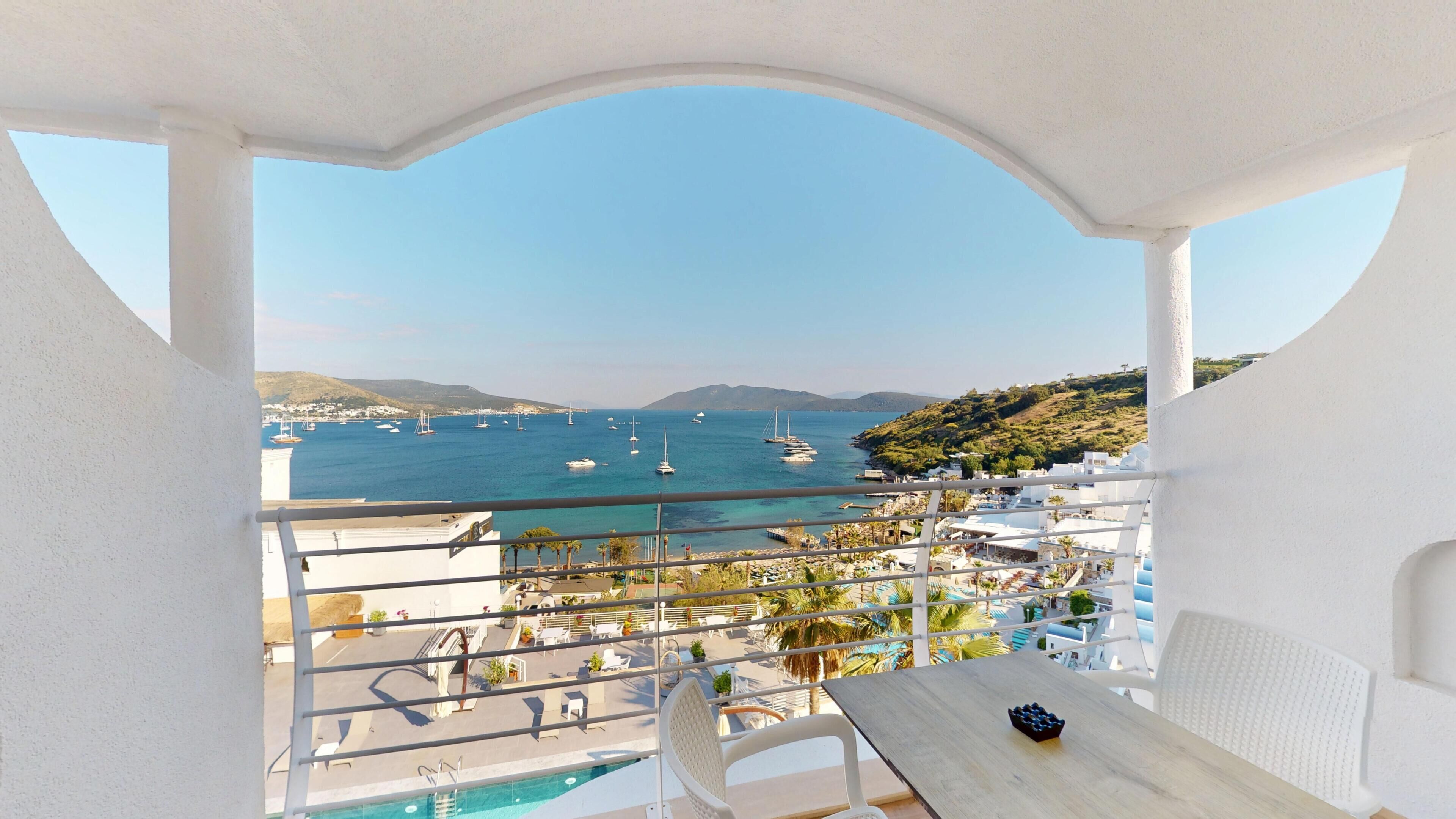 A balcony with a view of a marina and the sea.