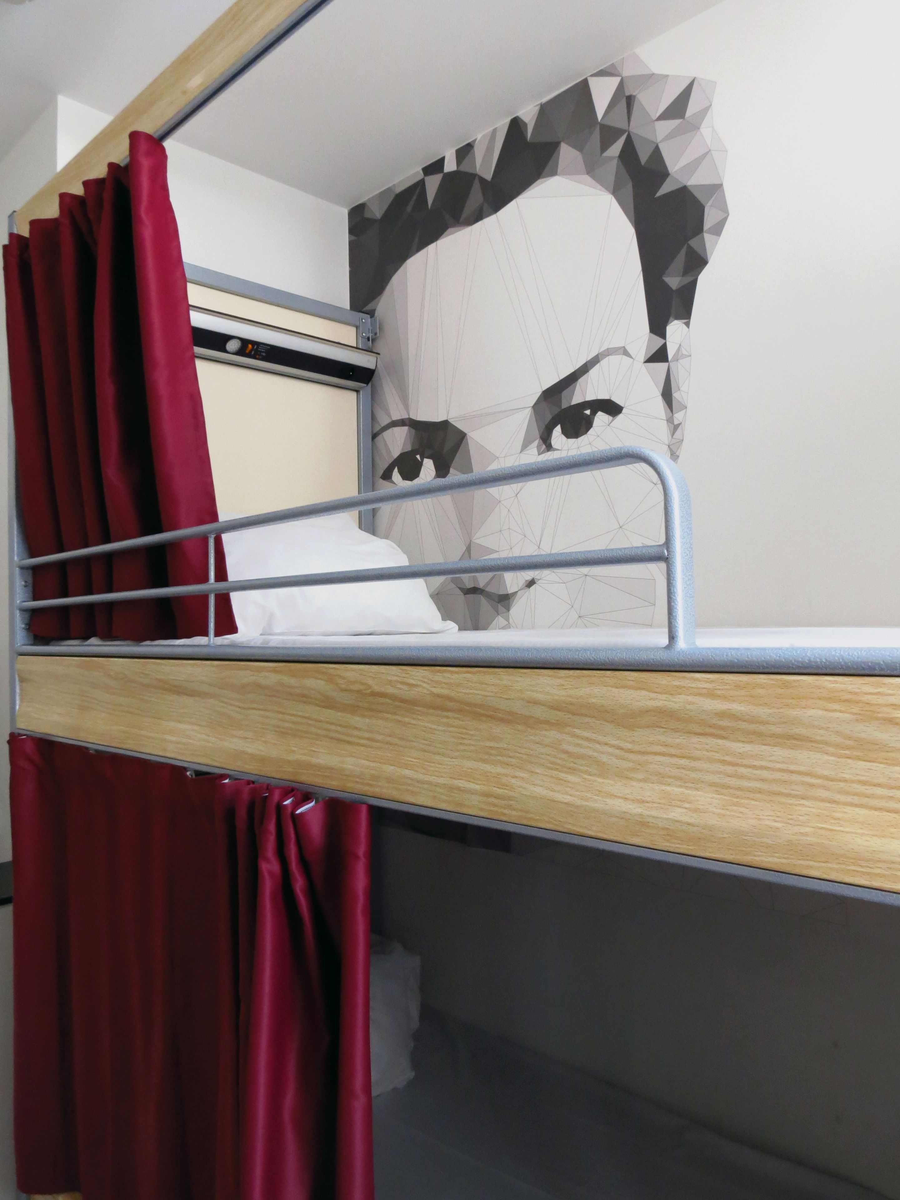 A bunk bed with a geometric-patterned wall behind it.