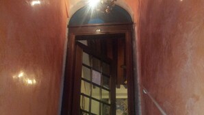 Una escalera con alfombra roja que conduce a una puerta con un panel de vidrio.