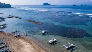 Privat strand, hvit sand, solsenger og parasoller