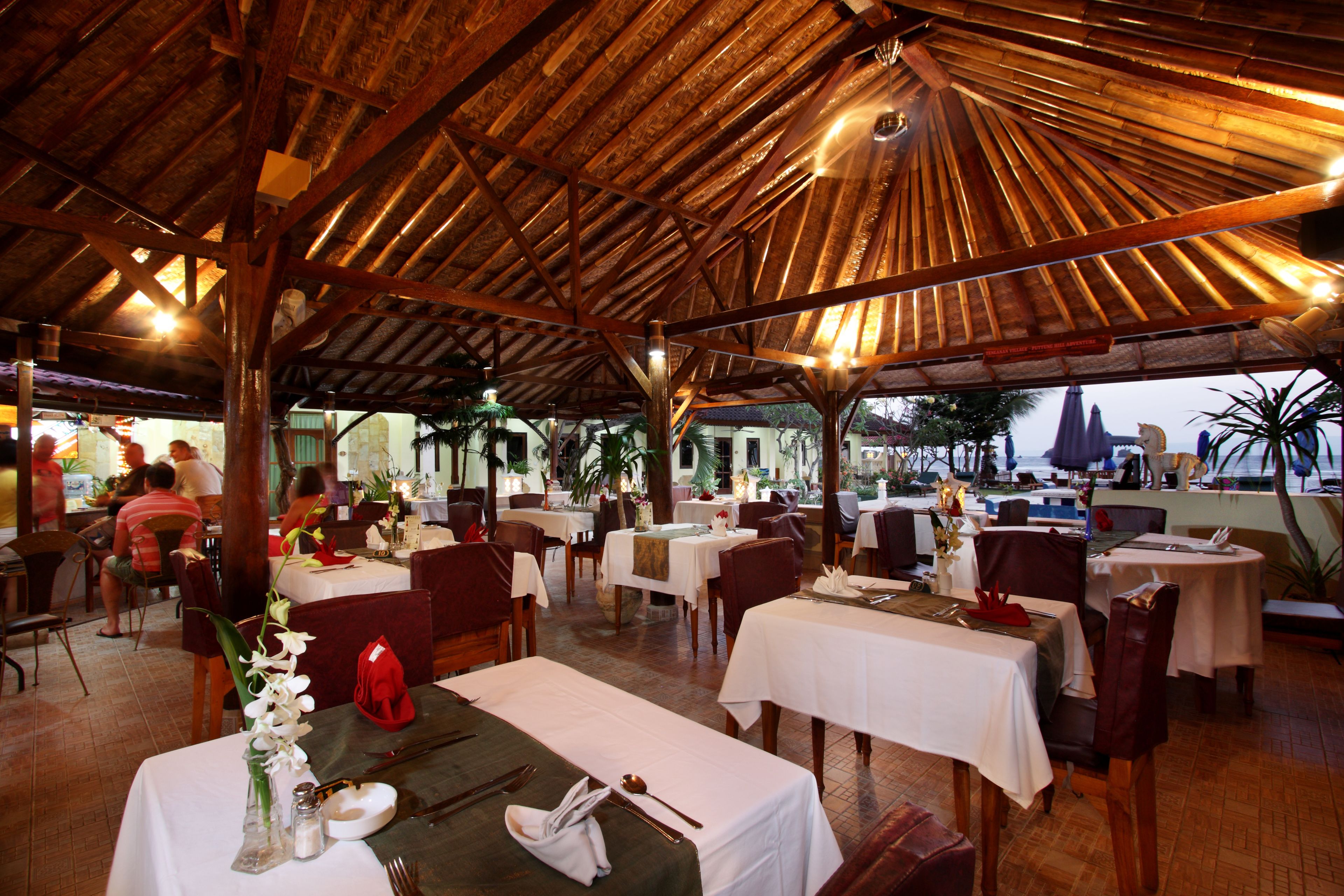 Ristorante interno con travi in legno e tavoli apparecchiati per consumare i pasti.
