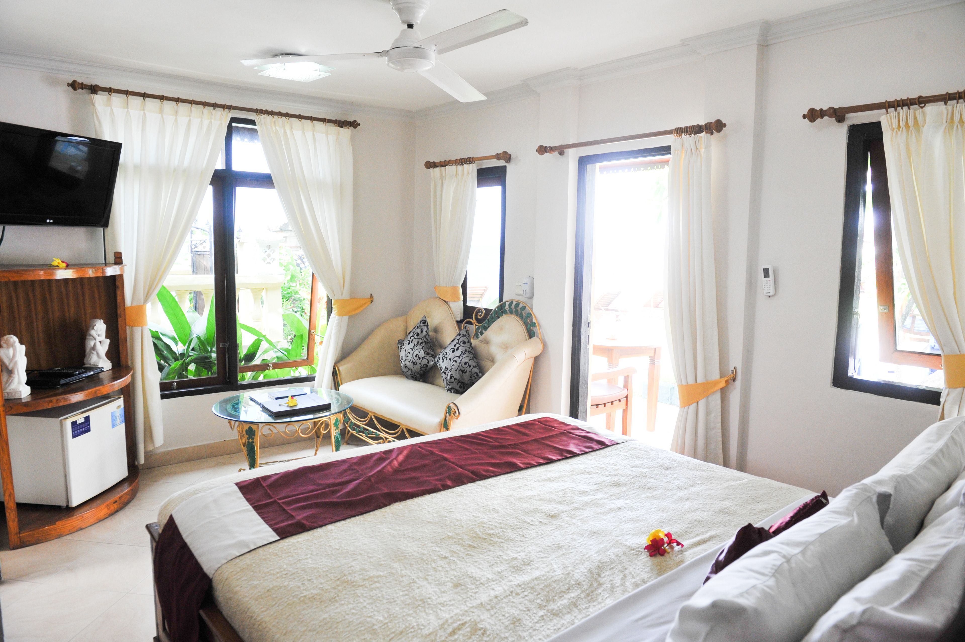 Una habitación de hotel con cama, televisión, escritorio y silla.