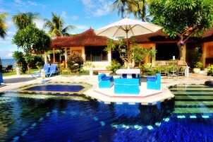 Una piscina al aire libre, sombrillas, tumbonas