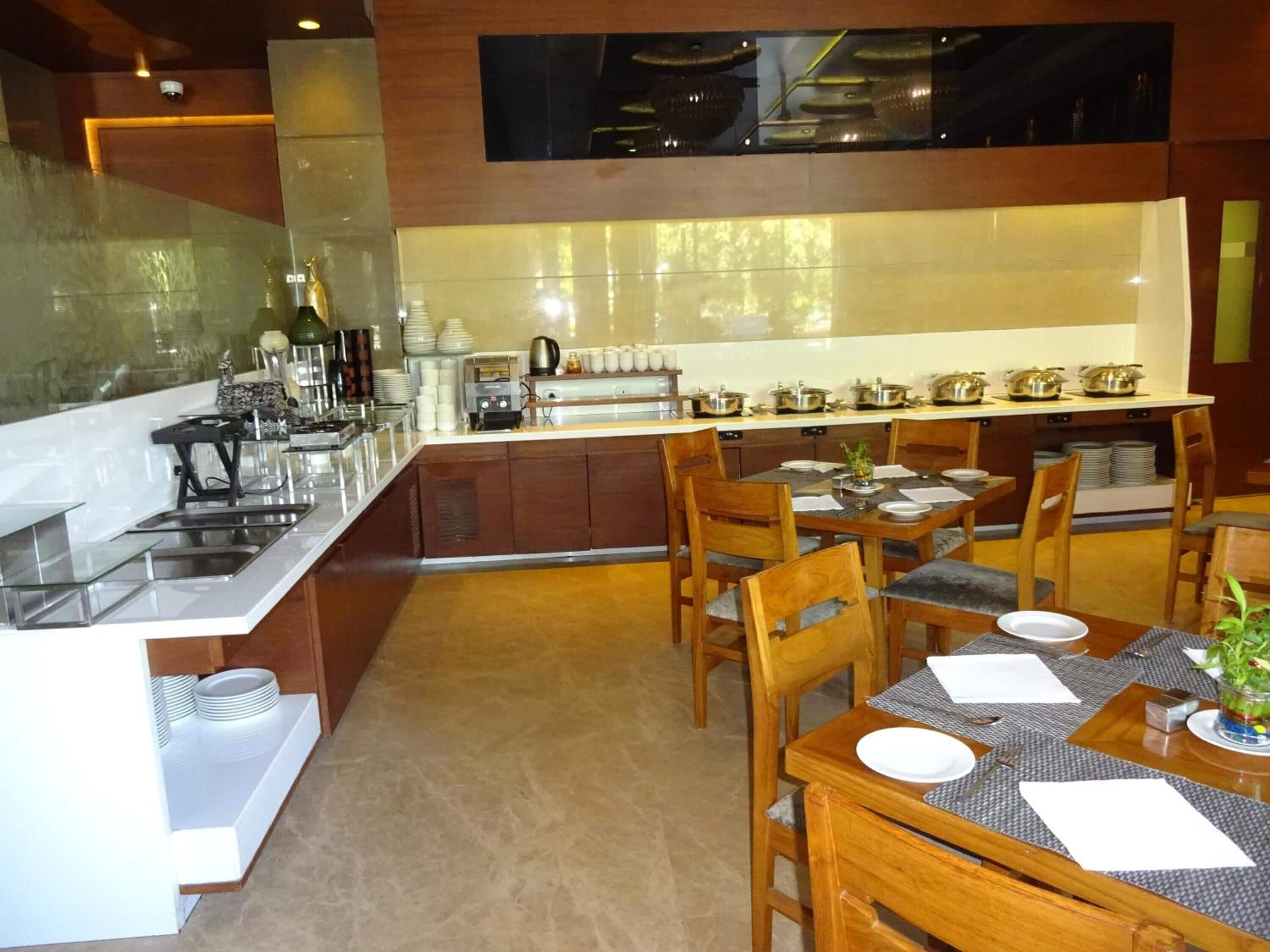 Una cocina moderna con una isla central, sillas de madera y una mesa de comedor para cuatro.