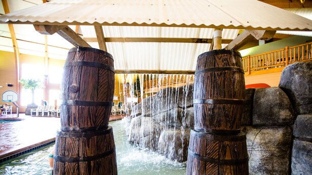 Ein Wasserspiel mit Holzfässern und einem Poolbereich.