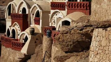 A traditional building with arched windows and a stone staircase leading to a door.