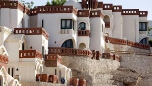 A white building with multiple arches and a stone staircase. - Umbi Sharks Bay Diving Village (Sharm El Sheikh)