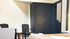Un dormitorio con cama, escritorio y silla.