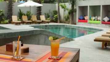 Una piscina al aire libre, sillones reclinables de piscina