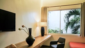 A hotel room with a wooden desk, a TV, a lamp, a chair, and a bed. -  Sonitori Boutique Resort (Phnom Penh)