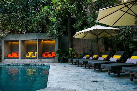 Una piscina al aire libre, sillones reclinables de piscina