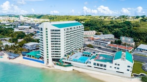 A high-rise hotel with multiple balconies, a pool area, and a beachside location. - Alupang Beach Tower (Tamuning)