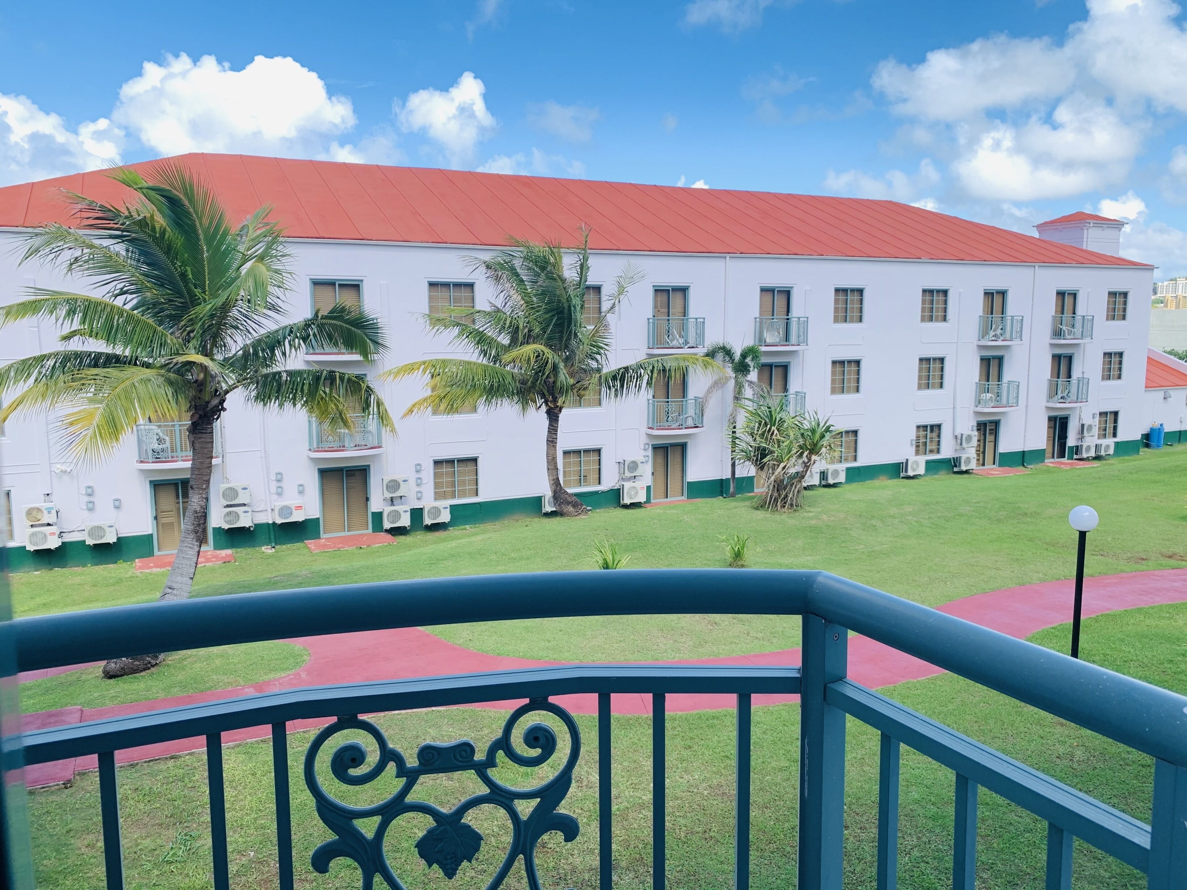 A multi-story hotel with a red roof, white exterior, and balconies.