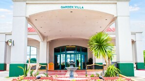 A building with a sign reading "Garden Villa" and a covered entrance. - Garden Villa Hotel (Tamuning)