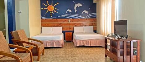 A hotel room with two beds, a TV, a desk, and a mural of a sun and dolphins.