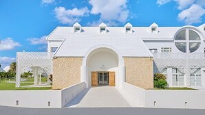 A large, modern building with a symmetrical facade, a central arched entrance, and a spacious courtyard. - Pricia Resort Yoron (Yoron)