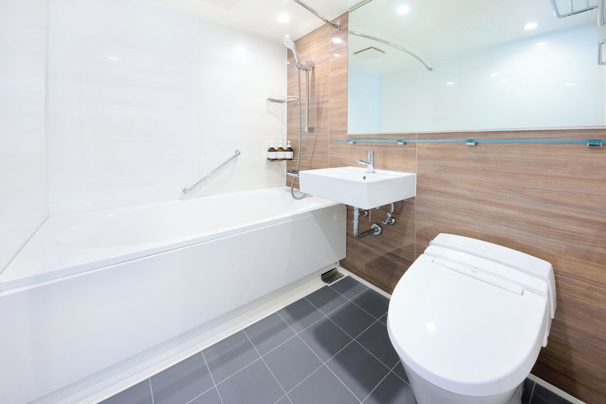 A modern bathroom with a white bathtub, a white sink, and a white toilet.
