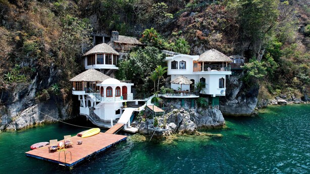 A coastal property with multiple buildings, a dock, and a clear blue sea. - Atitlan Oasis Eco Hotel and Spa Kaalpul (San Antonio Palopo)