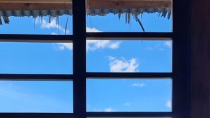 A window with a view of mountains and a body of water. - Atitlan Oasis Eco Hotel and Spa Kaalpul (San Antonio Palopo)
