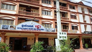A multi-story building with a sign for "Rotha Guest House and Apartment" and a contact number. - Rotha Guesthouse (Siem Reap)