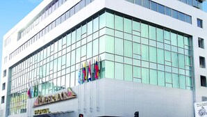 A modern building with a glass facade and a sign reading "Emperador." - Hotel Emperador (Ambato)