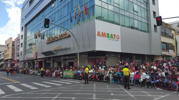 A hotel with a modern glass facade, a visible sign for 'AMBATO', and a 'HOTEL' sign below. - Hotel Emperador (Ambato)