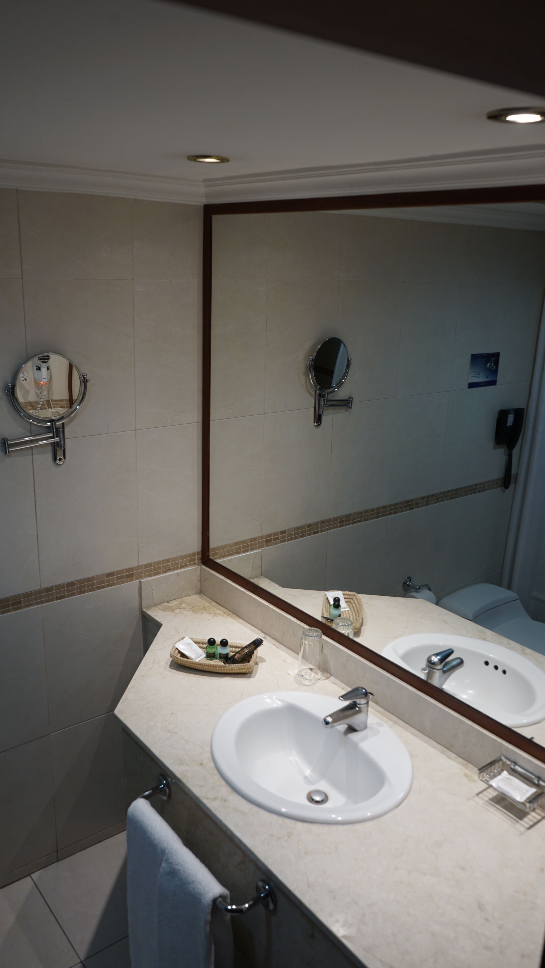 A bathroom with two sinks, a large mirror, and a towel rack.
